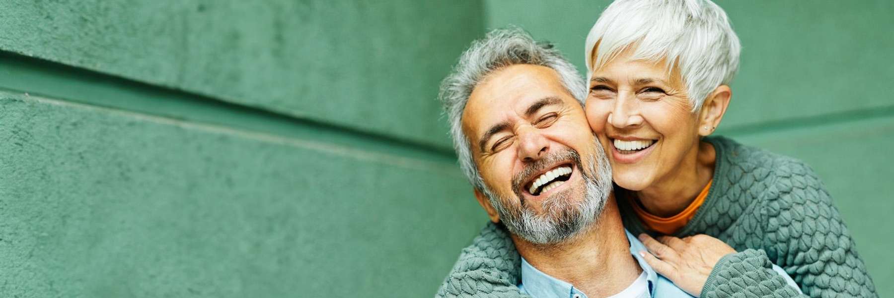 An elderly man and woman smiling after a Dental Implants service in Durham