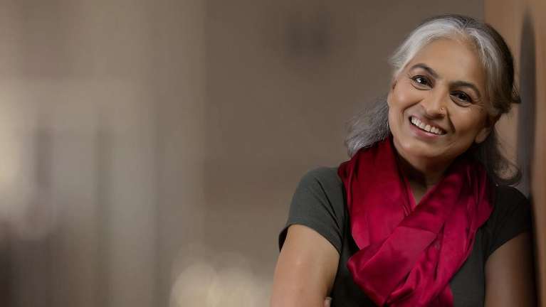 A woman smiling after getting dentures in Durham, NC